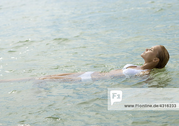Frau entspannt im flachen Wasser