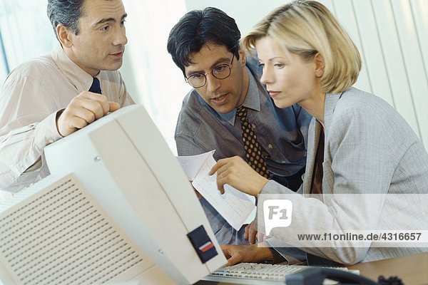 Business associates working at desktop computer