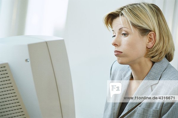 Businesswoman using desktop computer  frowning