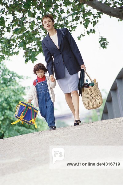 Geschäftsfrau zu Fuß mit Sohn