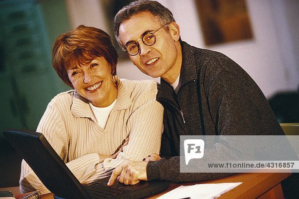 Senior couple using laptop  portrait