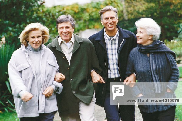 Two senior couples walking outdoors  front view