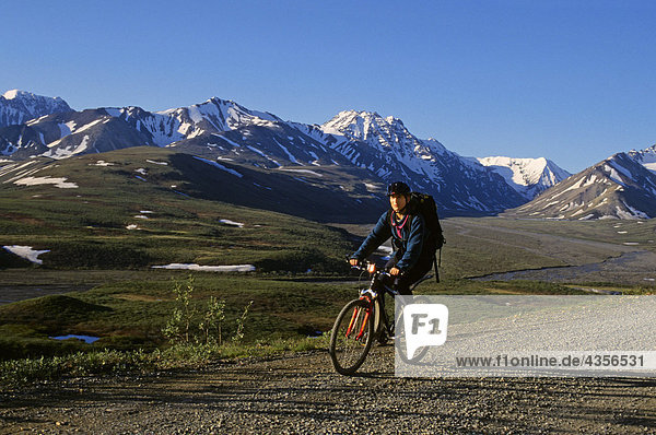 Frau Fahrradfahren auf Denali National Park Road Inland Alaska Frühling