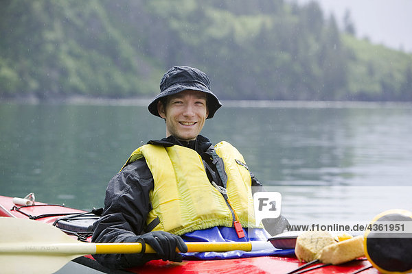 Close up portrait of caucasian male in kayak on Aialik Bay within Kenai Fjords National Park summer Southcentral Alaska