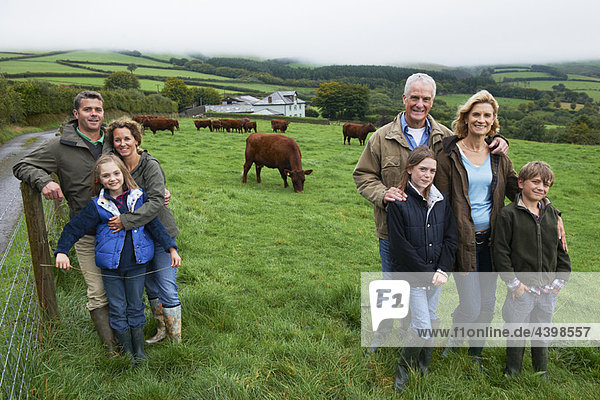 Familie auf dem Bauernhof in einem Feld mit Kühen