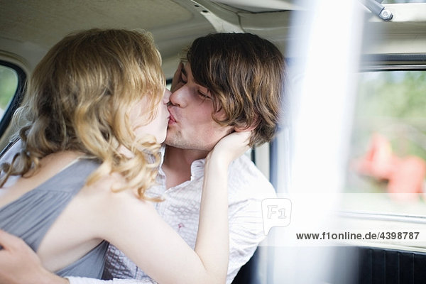 Liebende küssen sich im Auto