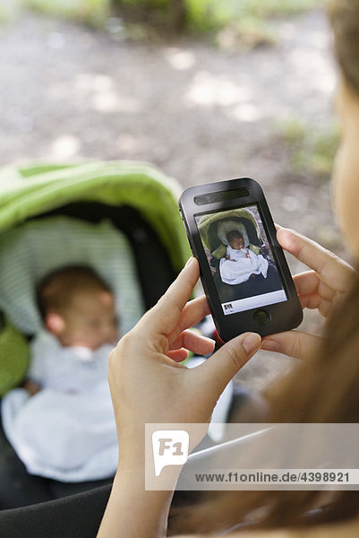 Mother photographing baby on phone