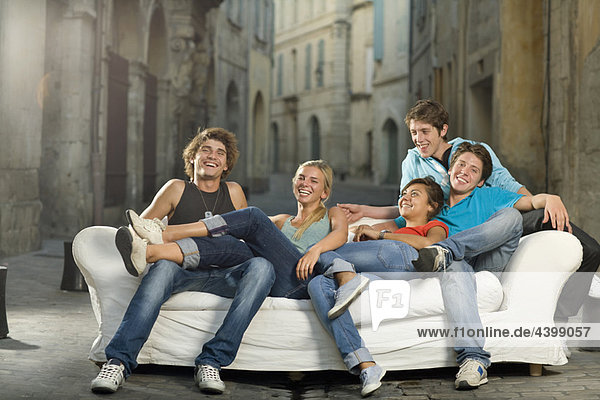 Gruppe entspannen auf der Couch lachend in der Straße