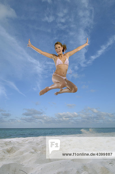 Frau beim Springen am Strand