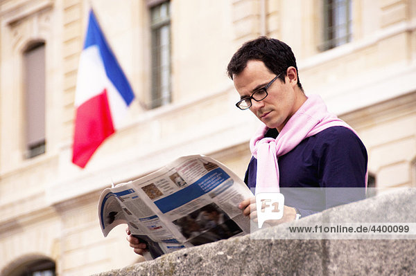 Mann liest Zeitung in Paris