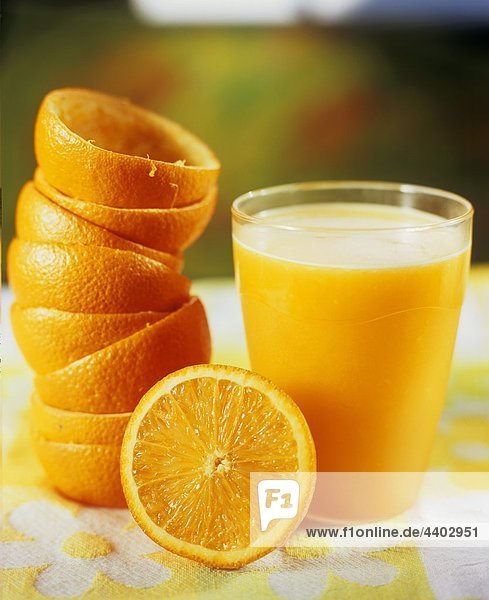 Ein Glas Orangensaft mit gepressten Orangen
