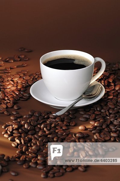 Eine Tasse schwarzen Kaffee und Kaffee-Bohnen