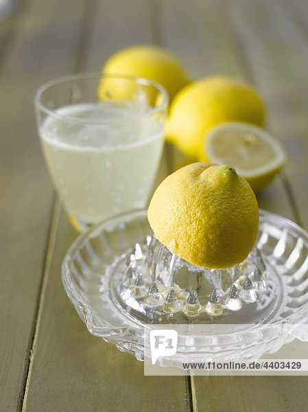 Lemon squeezer  lemons and a glass of hot lemon