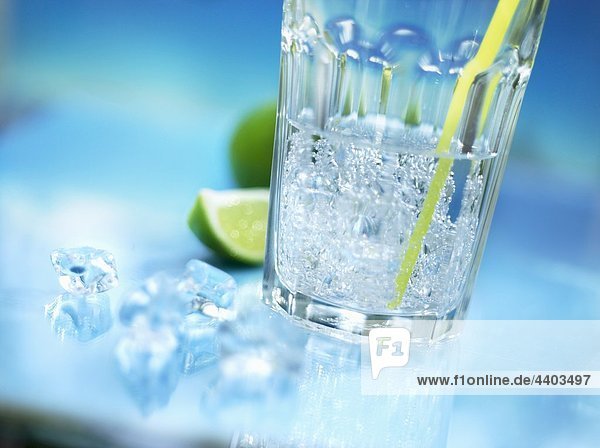 Ein Glas Mineralwasser mit Stroh  crushed Ice und Limette