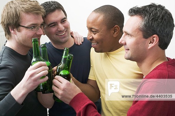 Vier Männer klirrend Flaschen Bier
