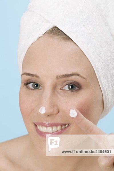 Frau mit einem Gesichtscreme auf Nase und Finger-blob