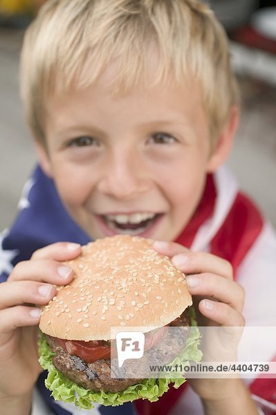 Kleiner Junge Hamburger hält (4. Juli  USA)