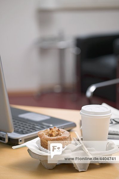 nebeneinander neben Seite an Seite Tasse Notebook Büro Kaffee Muffin