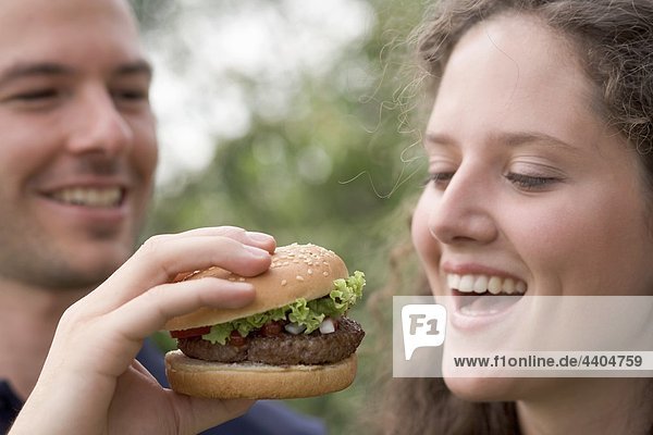 Mann mit Frau einen Bissen von hamburger
