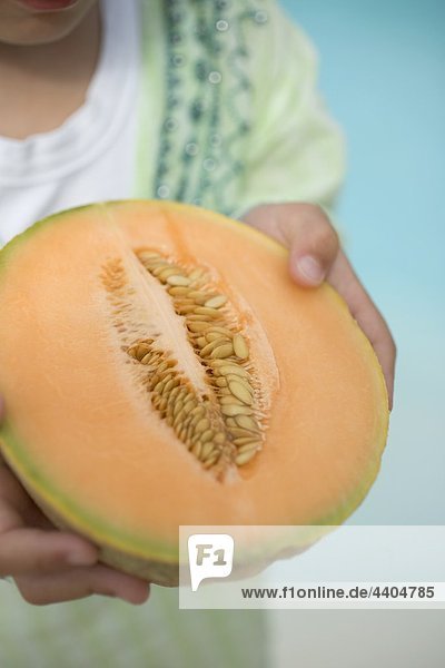 Kind halten die Hälfte eine Cantaloupe-Melone