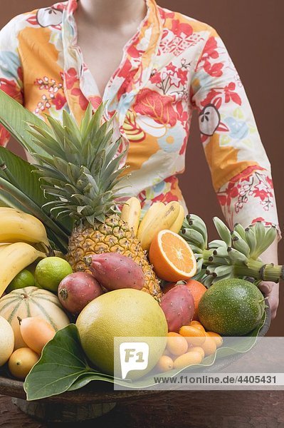 Frau hält Schüssel mit exotischen Früchten
