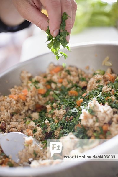 Sprinkling parsley into bread stuffing