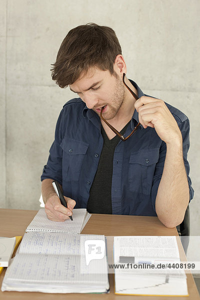 Young man writing and studying in univeristy