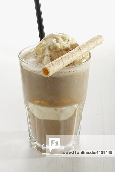 Glass of iced coffee with ice cream and wafer on white background