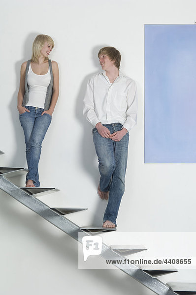 Teenage couple standing on stairway