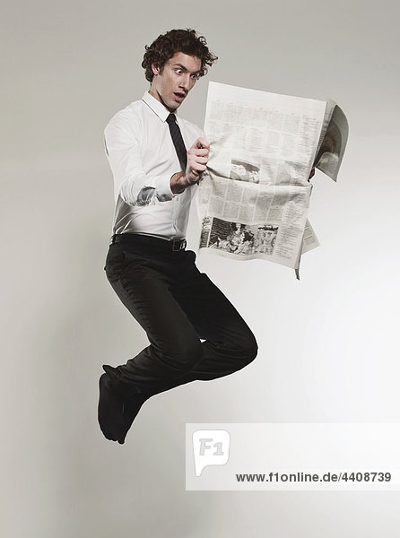Mann beim Zeitungslesen und Springen