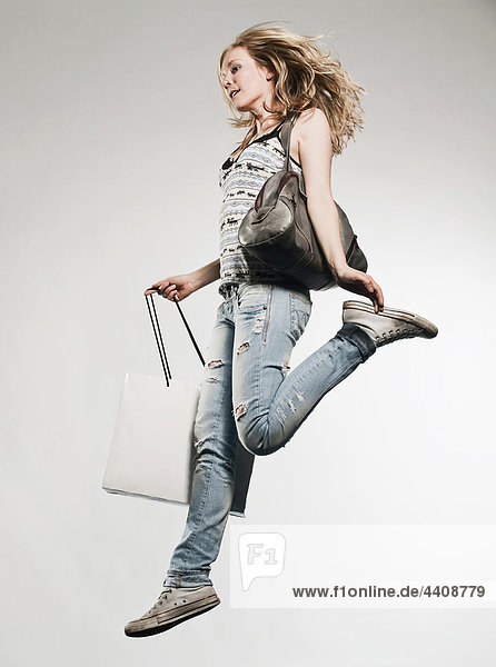Frau mit Einkaufstaschen auf grauem Hintergrund