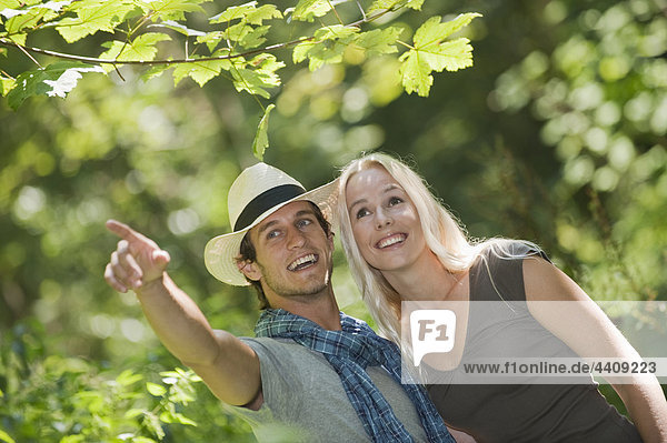 Young couple in forest  man pointing away