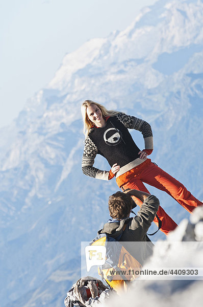 Österreich,  Steiermark,  Dachstein,  Mann fotografiert Frau auf Berggipfel
