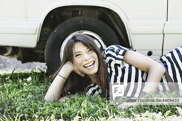 Junge Frau entspannt sich im Gras  lächelnd