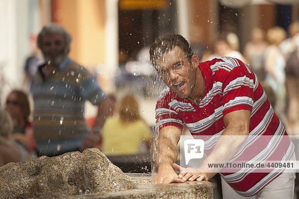 Man playing with fountain water