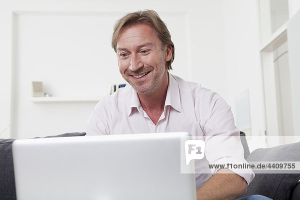 Mann mit Laptop  lächelnd