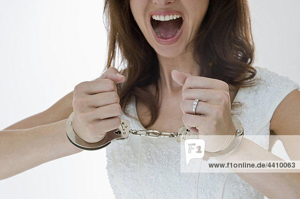 Midsection of bride with handcuffed and shouting
