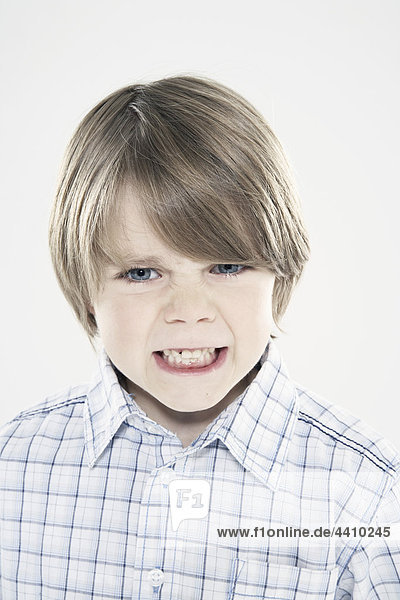 Junge (8-9) mit zusammendrückenden Zähnen  Nahaufnahme  Porträt