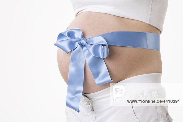 Schwangere Frau mit blauem Band um den Bauch  Mittelteil