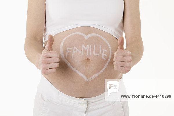 Herzform auf den Bauch der Schwangeren gezeichnet mit Text  mit Daumen nach oben Zeichen