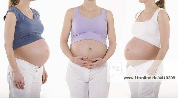 Drei schwangere Frauen stehend  Mittelteil