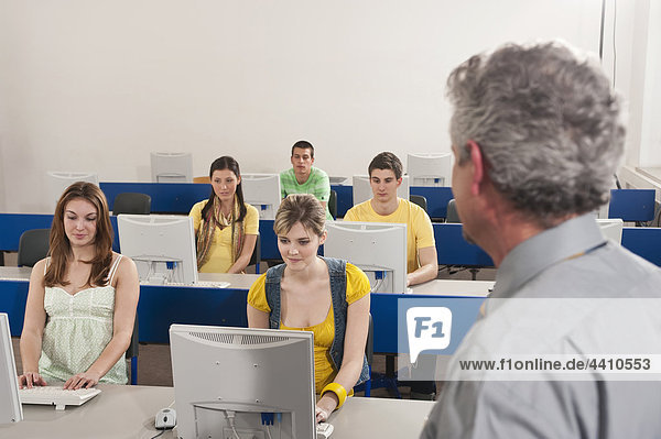 Deutschland Emmering Dozent beobachten Studenten mit Computer im Computerlabor