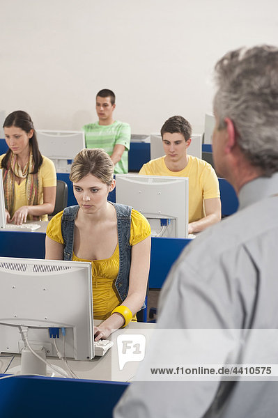 Deutschland Emmering Dozent beobachten Studenten mit Computer im Computerlabor