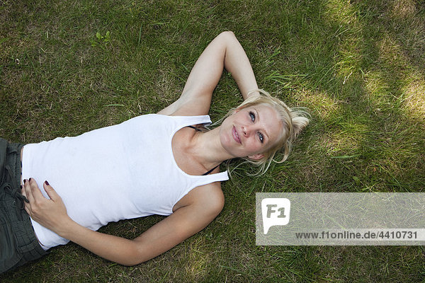 Junge Frau ruht auf Gras  lächelnd