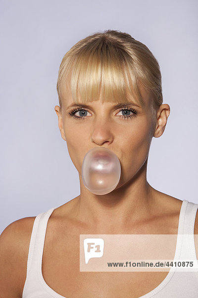 Young woman blowing bubble gum  portrait  close-up