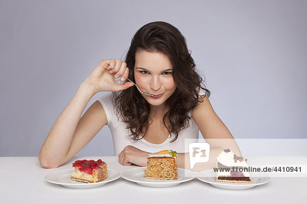 Junge Frau mit 3 Teller Kuchen  Portrait