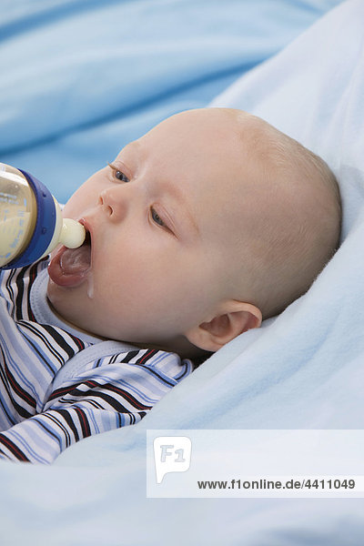 Babyboy (6-11 Monate) hält Babyflasche  Mund offen