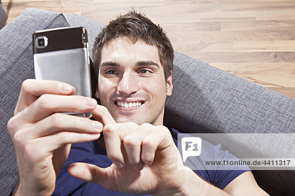 Mann SMS auf dem Handy  lächelnd  Nahaufnahme