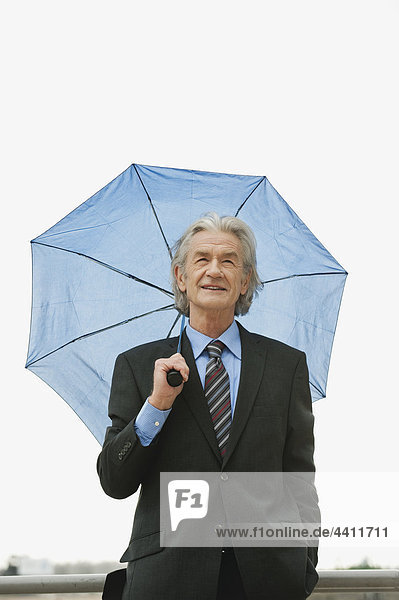 Deutschland  Hamburg  Geschäftsmann mit Schirm  wegschauend