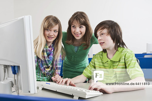 Junge mit Computer und Mädchen beobachtend  lächelnd